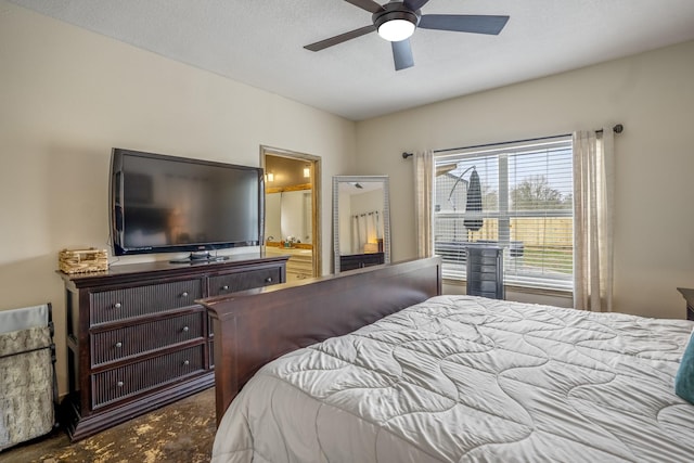 bedroom featuring ceiling fan, ensuite bathroom, and a textured ceiling