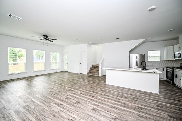 1415 E 35th St, Houston, TX 77022 - unfurnished living room with ceiling fan, wood finished floors, and stairs