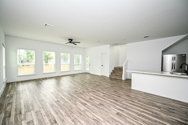 1415 E 35th St, Houston, TX 77022 - unfurnished living room featuring wood finished floors, ceiling fan, and stairway