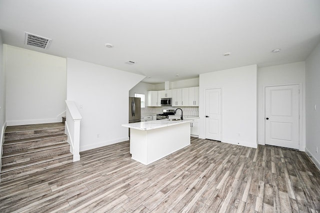 1415 E 35th St, Houston, TX 77022 - kitchen with stainless steel appliances, light wood-style flooring, white cabinets, and light stone countertops