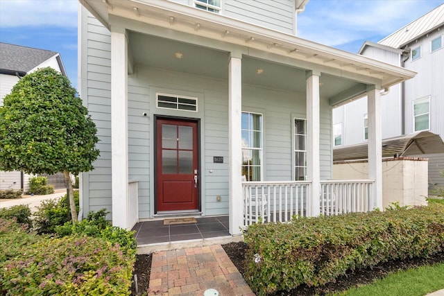 view of exterior entry featuring covered porch