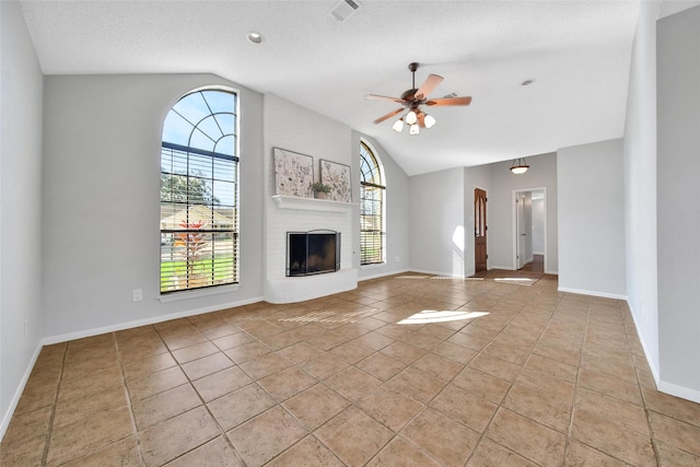 unfurnished living room featuring a brick fireplace, a wealth of natural light, and vaulted ceiling