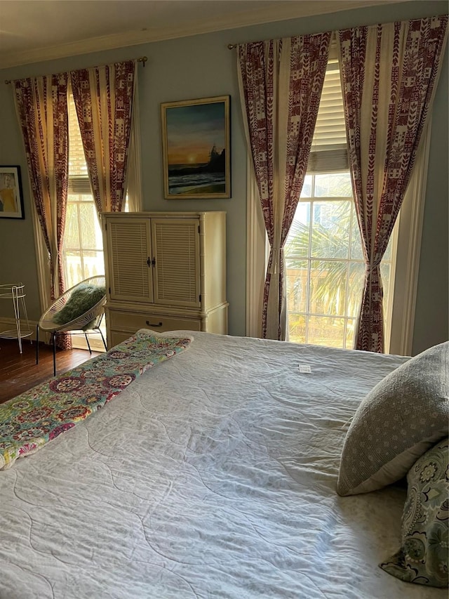 bedroom with crown molding and hardwood / wood-style floors