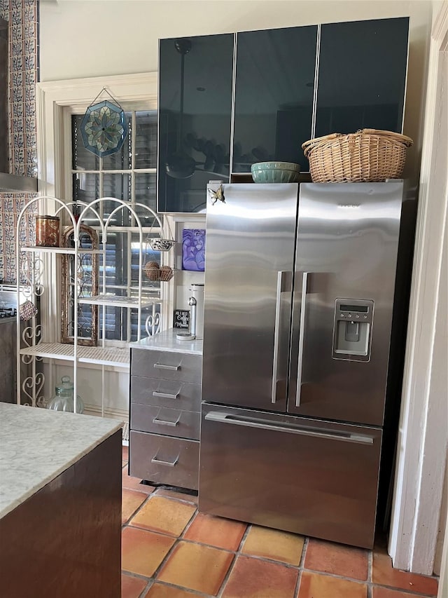 kitchen with high end fridge and light tile patterned floors