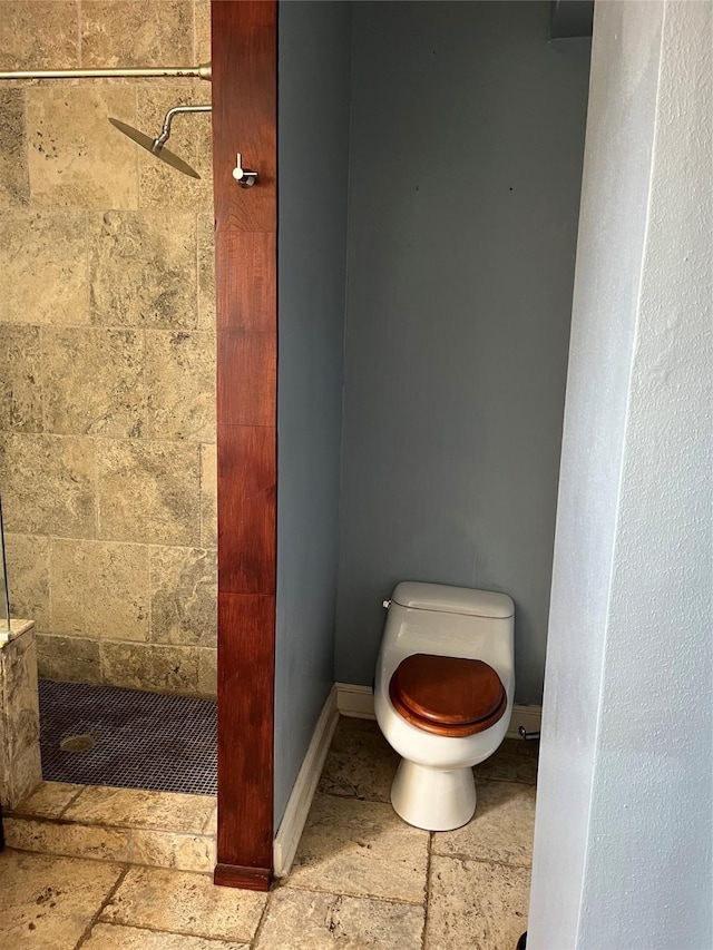 bathroom with toilet and a tile shower