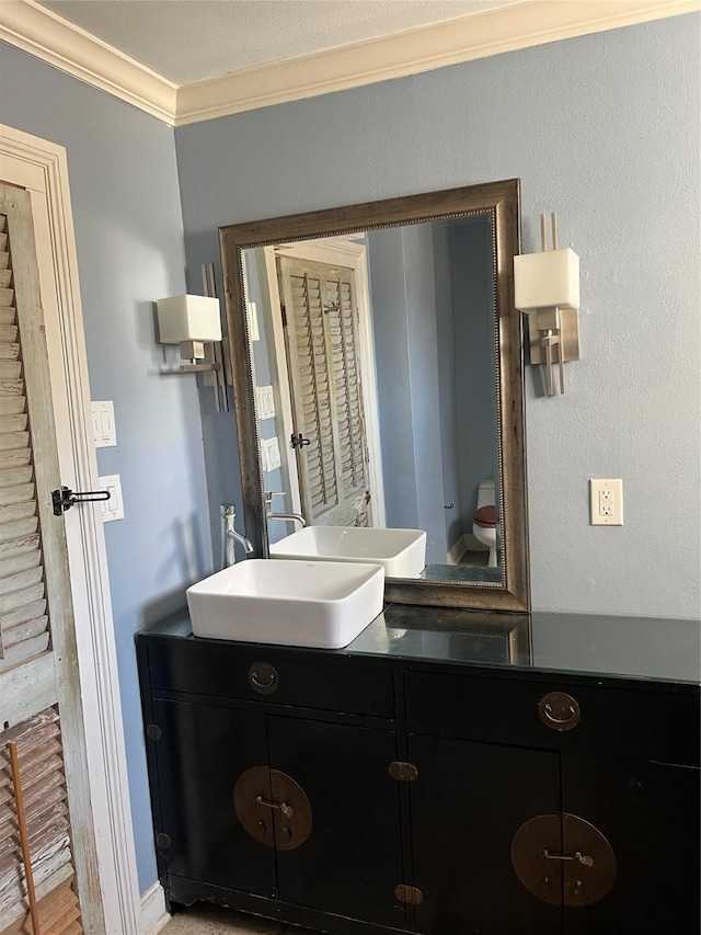 bathroom featuring crown molding, vanity, and toilet