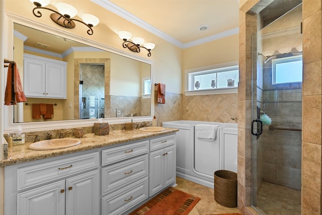 bathroom with tile patterned floors, ornamental molding, tile walls, vanity, and walk in shower