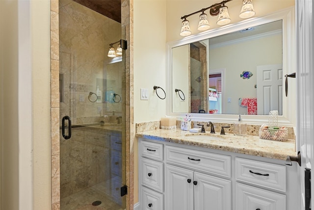 bathroom featuring ornamental molding, vanity, and a shower with shower door