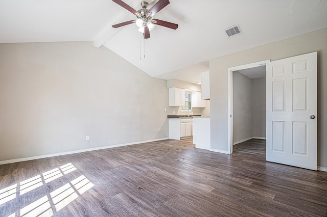 unfurnished living room with vaulted ceiling with beams, dark wood-type flooring, sink, and ceiling fan