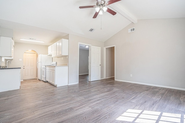 unfurnished living room with vaulted ceiling with beams, ceiling fan, sink, and light wood-type flooring