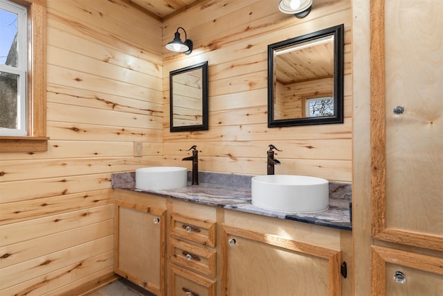 bathroom featuring vanity and wood walls