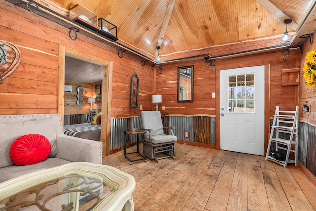 living area with lofted ceiling, wooden walls, light wood-type flooring, and wooden ceiling