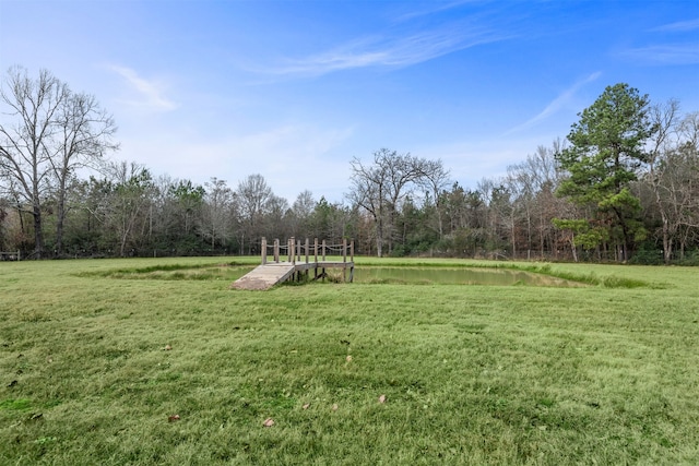 surrounding community featuring a water view and a lawn