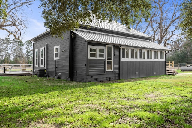 view of side of home featuring central air condition unit and a lawn