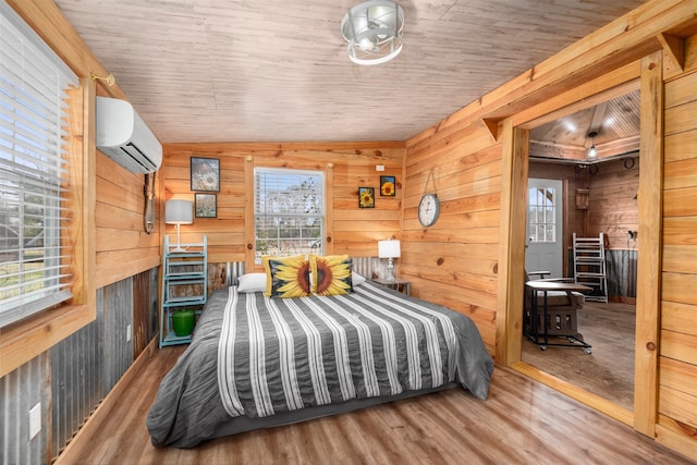 bedroom with a wall mounted air conditioner, wooden walls, hardwood / wood-style floors, and wooden ceiling