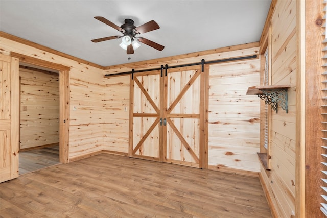 interior space featuring hardwood / wood-style floors, a barn door, and wood walls