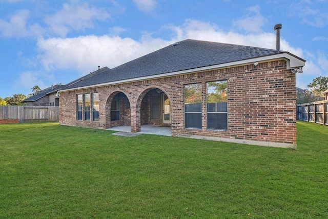 rear view of property featuring a yard and a patio area