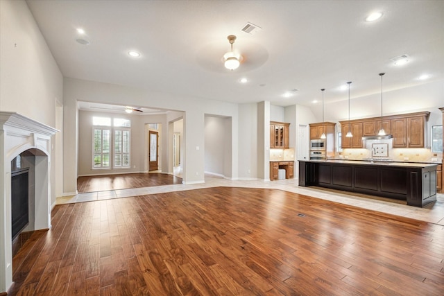 unfurnished living room featuring ceiling fan and light wood-type flooring