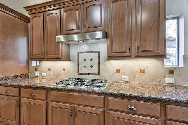 kitchen with tasteful backsplash, stainless steel gas cooktop, and dark stone countertops