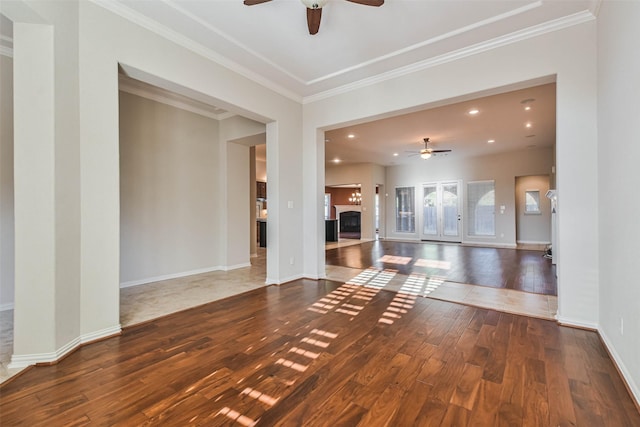 unfurnished living room featuring hardwood / wood-style flooring, crown molding, and ceiling fan