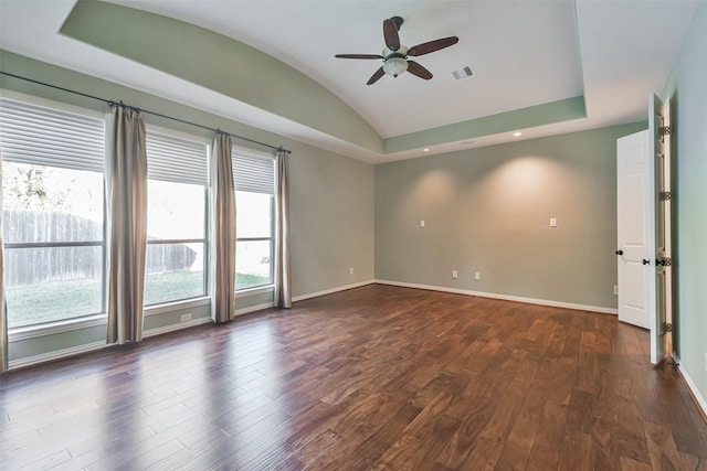 spare room with ceiling fan, lofted ceiling, dark hardwood / wood-style flooring, and a tray ceiling