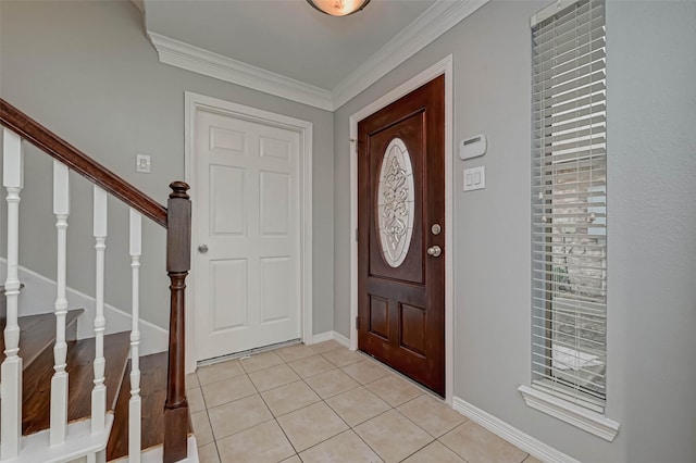 foyer with light tile patterned floors and crown molding