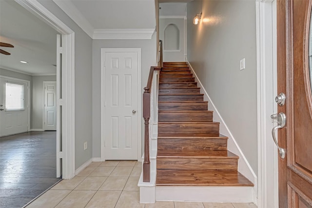 stairway featuring tile patterned flooring, ornamental molding, and ceiling fan