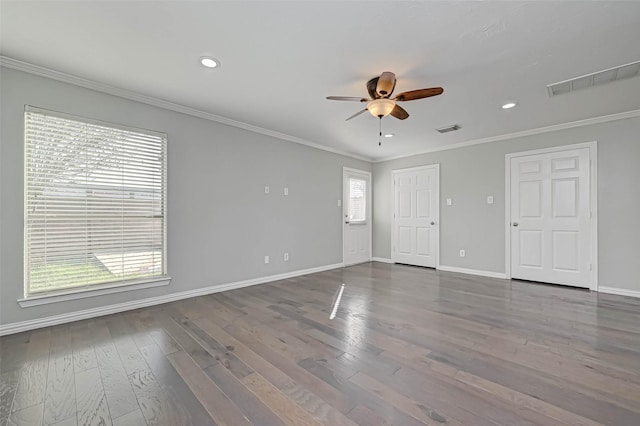 empty room with crown molding, hardwood / wood-style floors, and a wealth of natural light