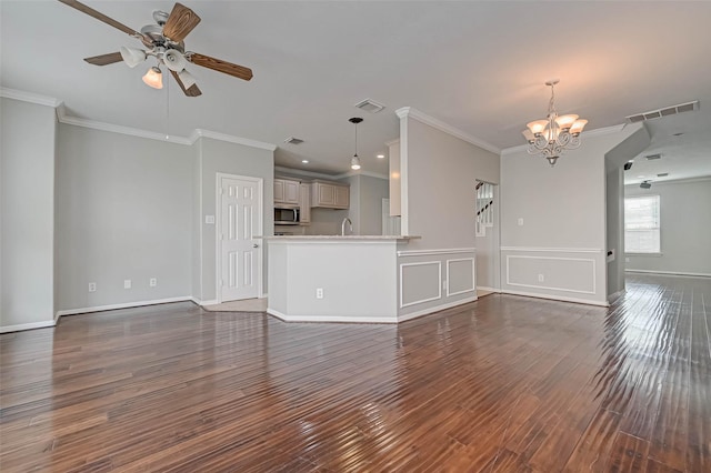 unfurnished living room with sink, ornamental molding, dark hardwood / wood-style floors, and ceiling fan with notable chandelier