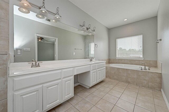 bathroom with vanity, tile patterned flooring, and tiled bath