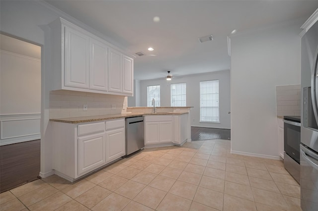 7816 Stoneyway Dr, Houston, TX 77040 - kitchen featuring appliances with stainless steel finishes, light tile patterned flooring, a sink, white cabinets, and recessed lighting