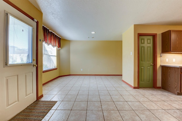 interior space featuring light tile patterned floors and a textured ceiling