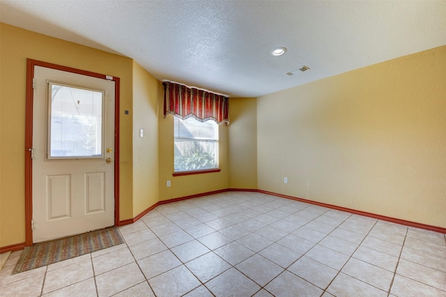 entrance foyer featuring a textured ceiling and light tile patterned floors