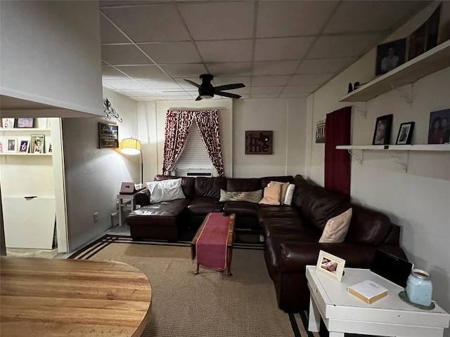 living room featuring a drop ceiling and ceiling fan