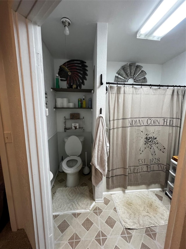 bathroom featuring a shower with curtain and toilet