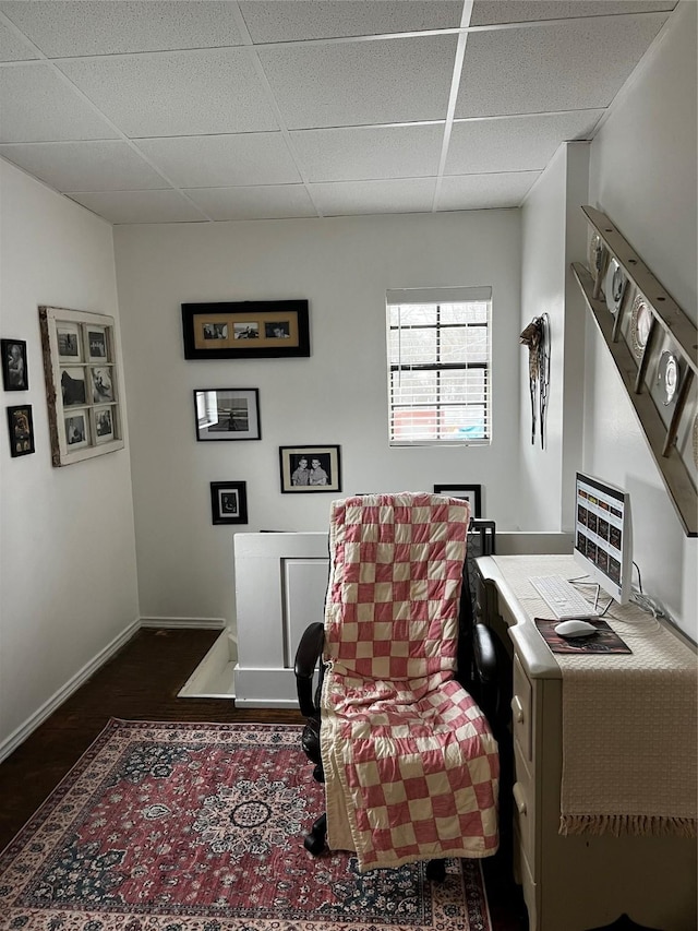 office area with dark hardwood / wood-style flooring and a paneled ceiling