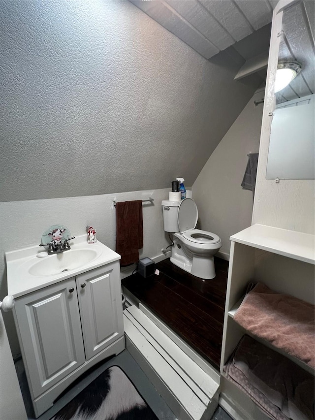 bathroom featuring lofted ceiling, hardwood / wood-style floors, vanity, a textured ceiling, and toilet