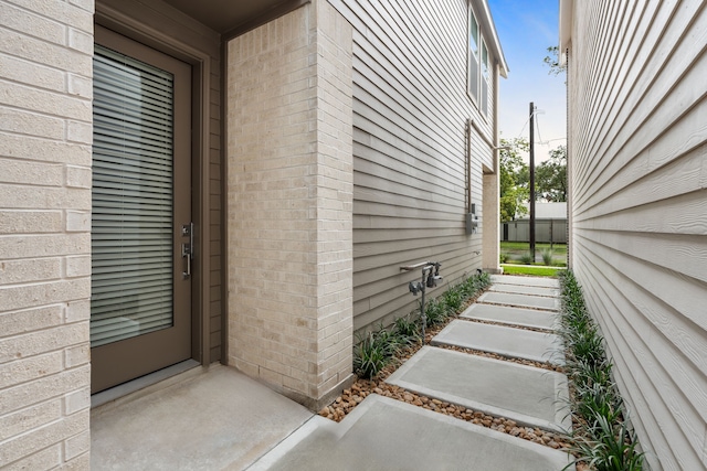 view of exterior entry featuring brick siding