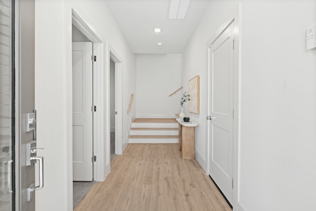 hall with light wood-type flooring and baseboards