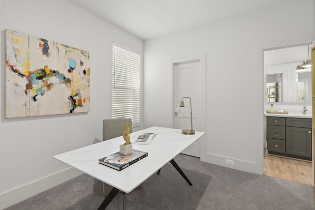 home office featuring a sink and light colored carpet