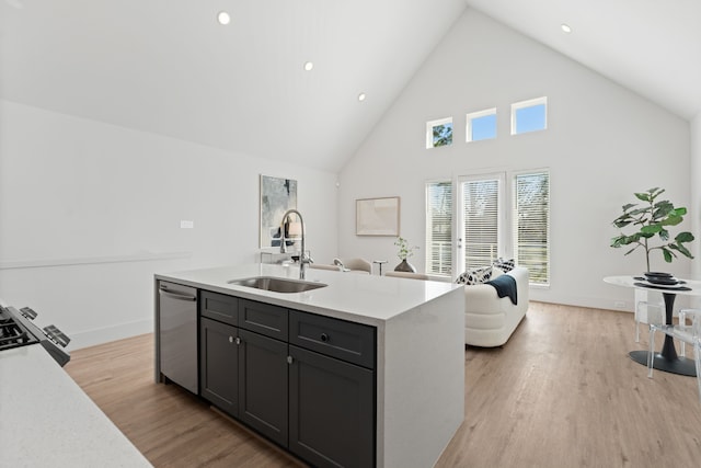 kitchen with a kitchen island with sink, a sink, open floor plan, light countertops, and dishwasher