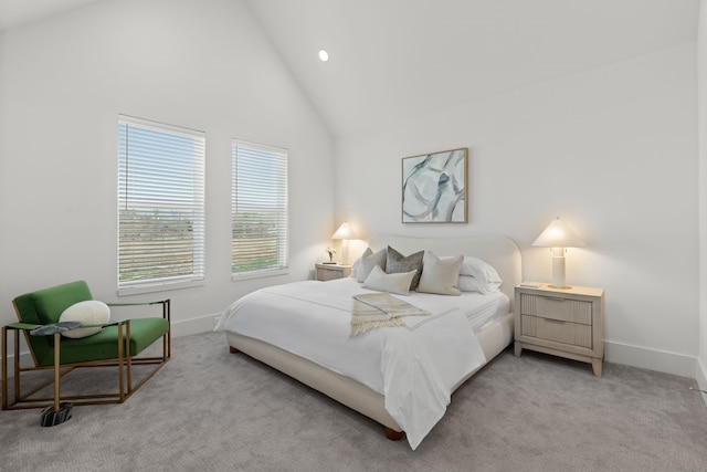 bedroom with high vaulted ceiling, light carpet, and baseboards