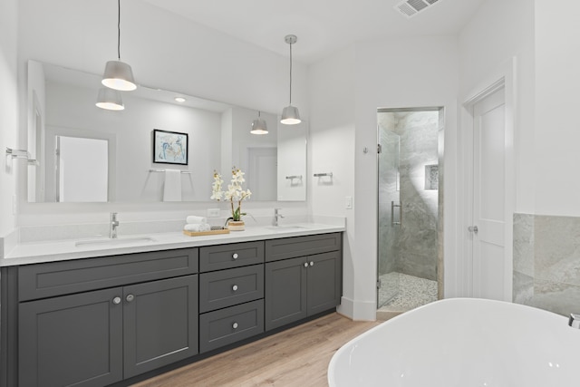 full bathroom featuring a stall shower, visible vents, a sink, and double vanity