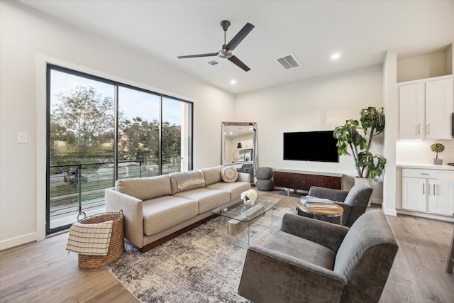 living room with light hardwood / wood-style floors and ceiling fan