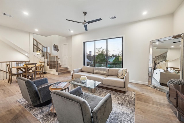 living room with ceiling fan and light hardwood / wood-style flooring