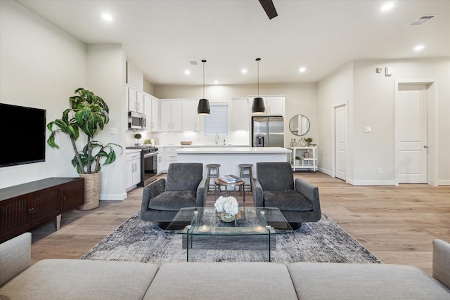 living room with sink and light hardwood / wood-style flooring