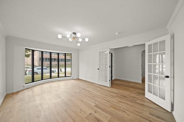 spare room with french doors, crown molding, an inviting chandelier, and light hardwood / wood-style flooring