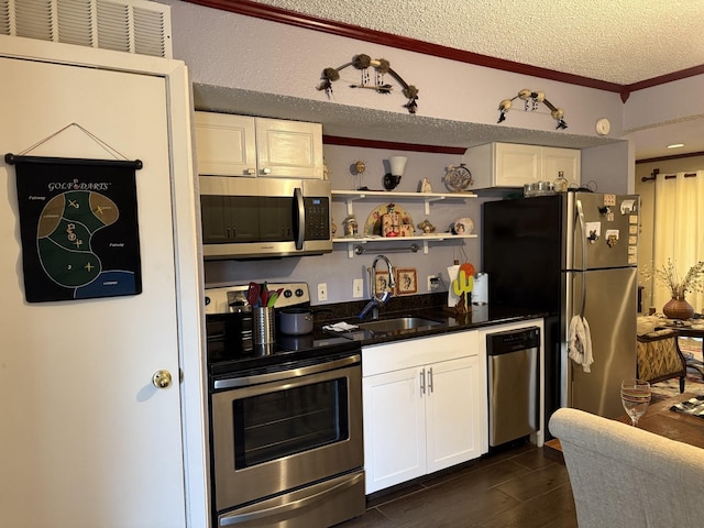 kitchen featuring sink, white cabinetry, stainless steel appliances, ornamental molding, and a textured ceiling