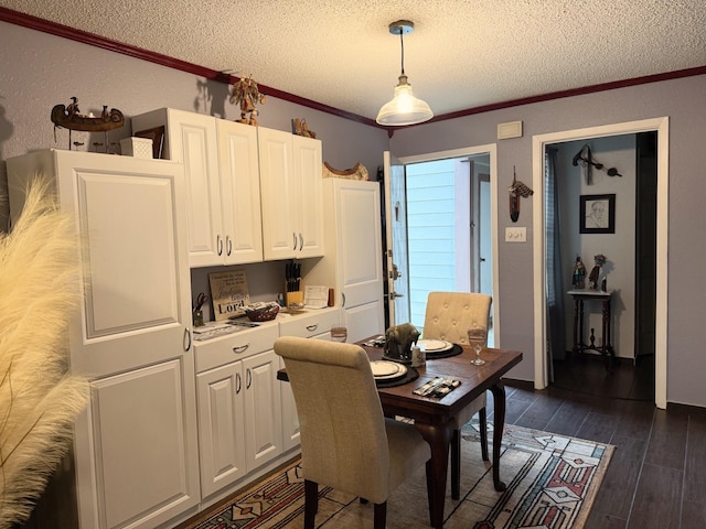 dining area with dark hardwood / wood-style flooring, crown molding, and a textured ceiling