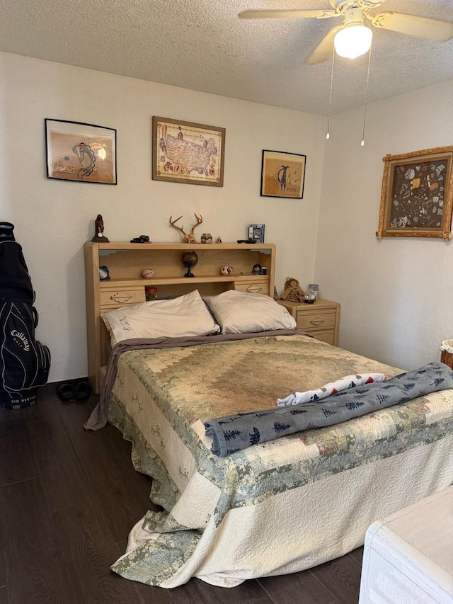 bedroom with dark wood-type flooring, ceiling fan, and a textured ceiling